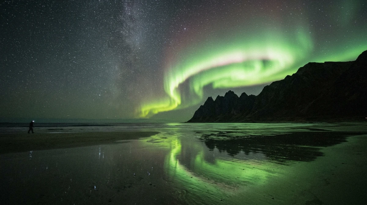 Aurora over the wet sand at Skagsanden, the reason many visitors come to Lofoten in winter