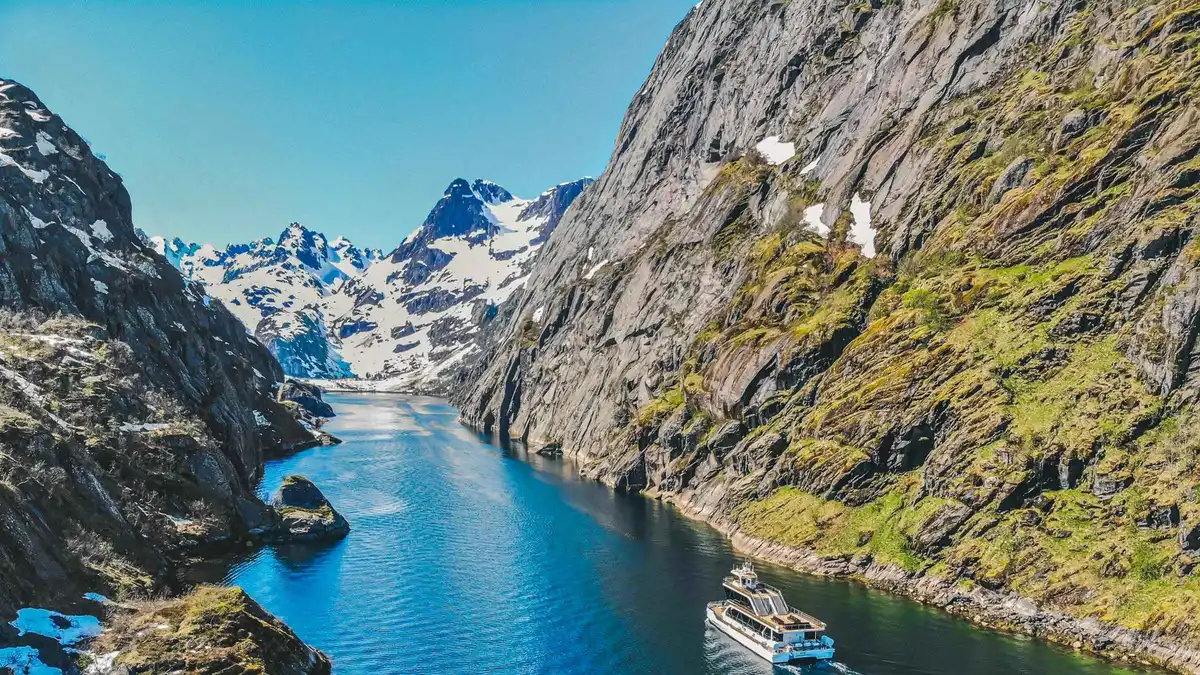 Brim Explorer's hybrid-electric catamaran gliding into the narrow mouth of Trollfjord on a silent Lofoten Islands tour from Svolvær