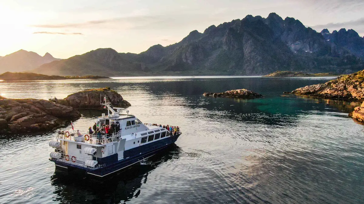 A covered tour boat approaching the 100-metre-wide entrance to Trollfjord on a Lofoten Islands cruise from Svolvær